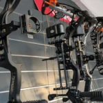 Compoundbögen hängen nebeneinander an der Wand.