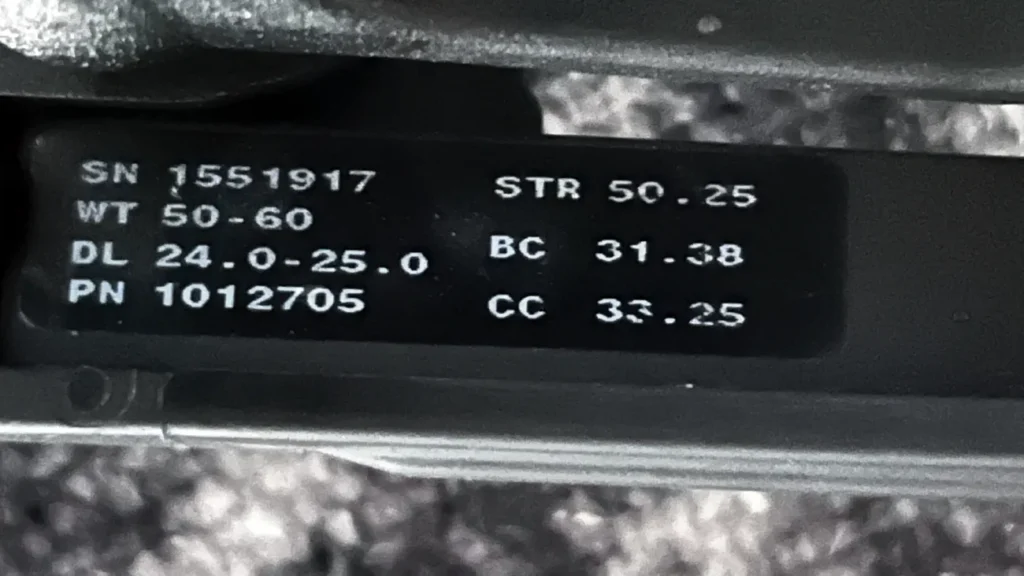 Angaben auf dem Wurfarm. Ablesbar sind Seriennummer, Zuggewicht, Einstelbereich Auszug, Sehnenlänge, Länge Kontrollkabel.