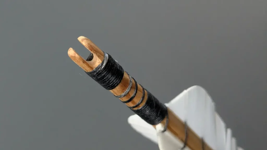 Direkt ins Holz eingearbeitete Selfnock eines Holzpfeils.